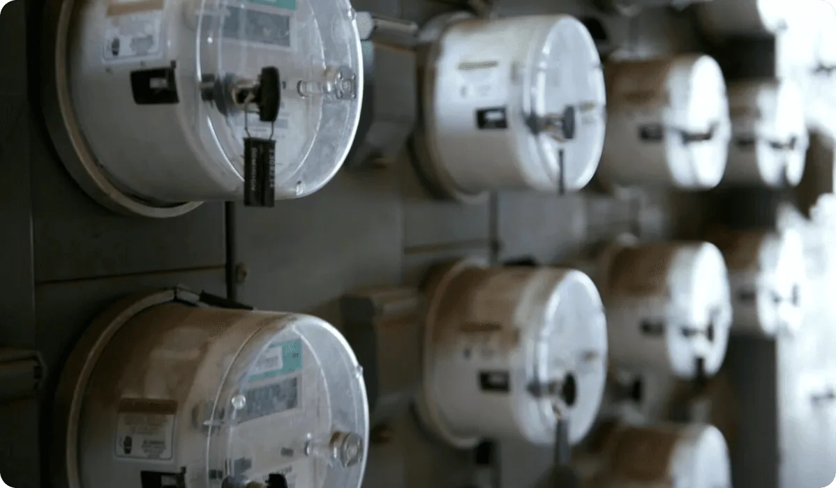 A wall of electric meters mounted in rows, one for each unit