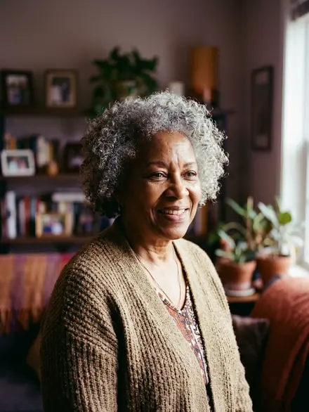 An older woman smiling in her living room
